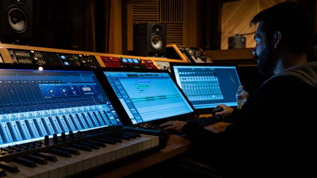 Person seated in front of a mixing cojnsole in a studio