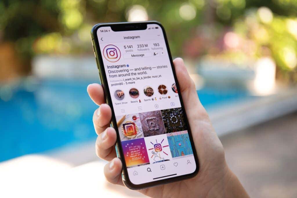 How to View Deleted Instagram Posts (Yours or Someone Else’s) image - Woman hand holding iPhone X with social networking service Instagram