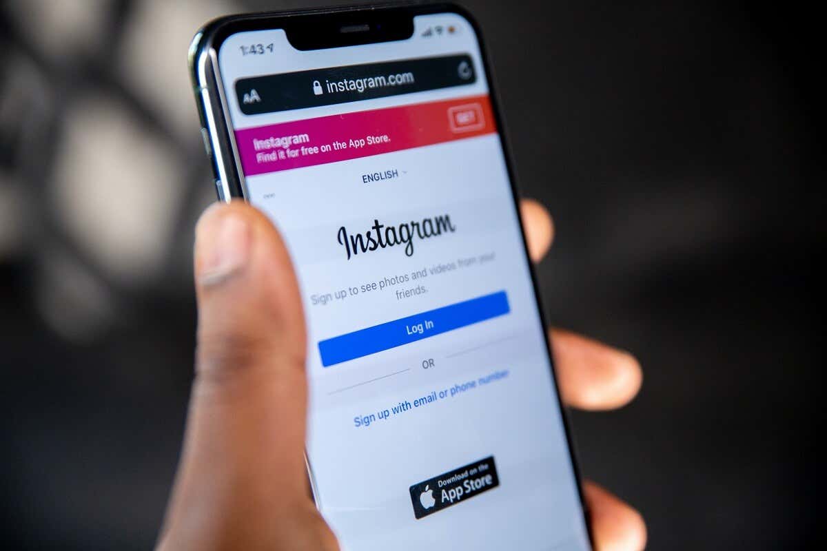 Someone holding an iPhone with the Instagram login page displayed on the screen